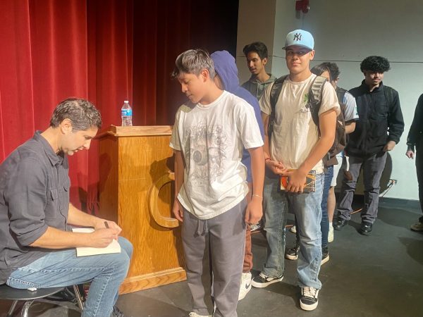 High school students wait in line on the Centaurus stage for Matt de la Peña to sign a copy of his book.