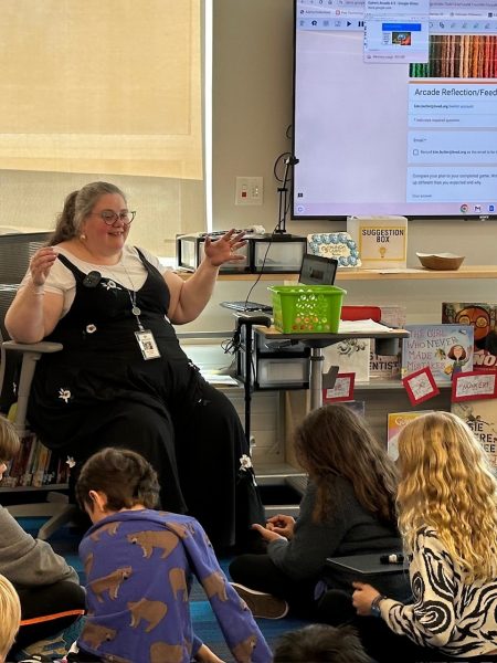 Teacher librarian Kim Butler sits in front of a class of kindergarten students.