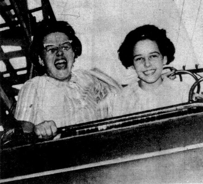 Two teenage girls ride a roller coaster