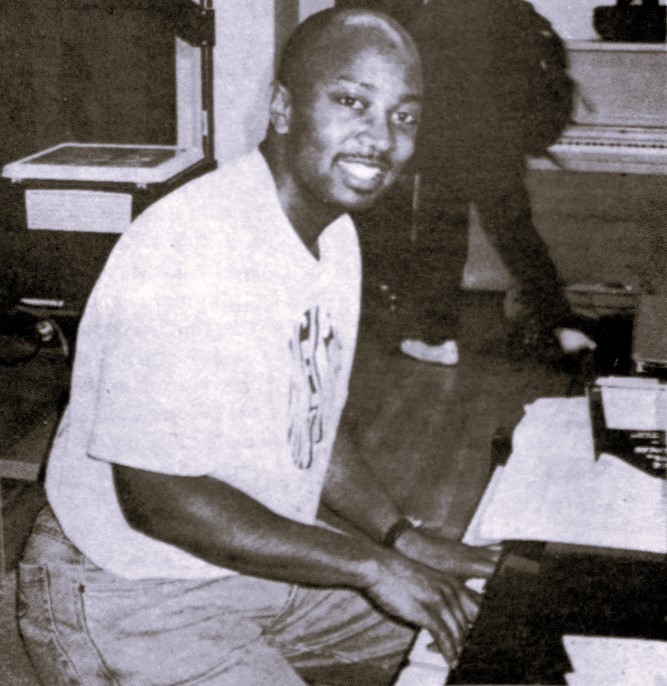 A high school music teacher sits at the piano.