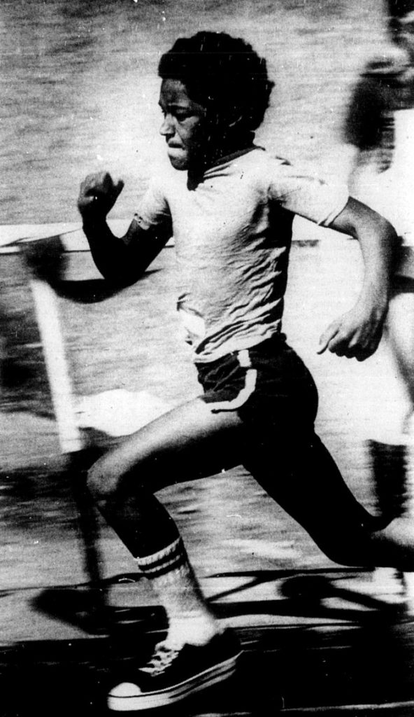 A young boy runs in a race.