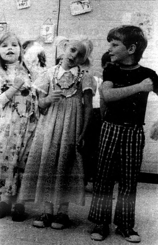 3 young children sing together.