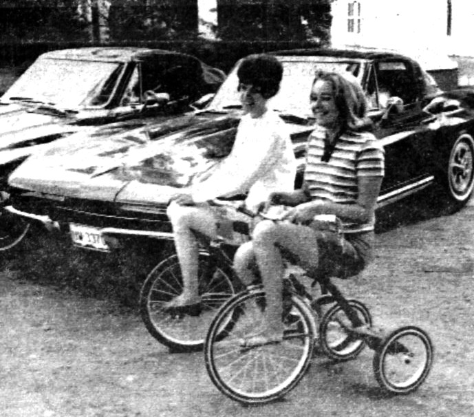 Two young women ride tricycles