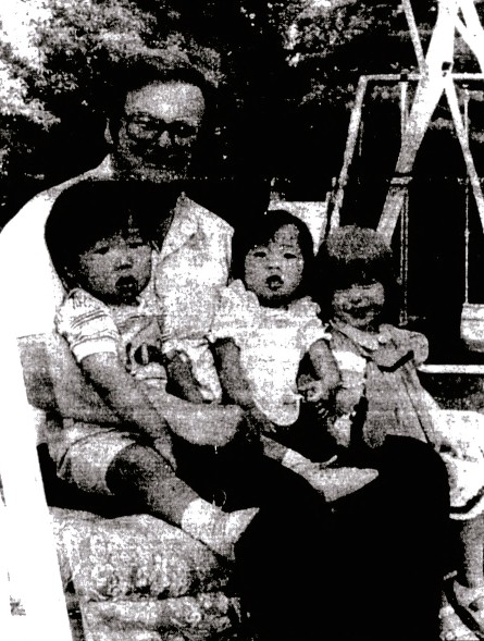 A father poses with his 3 young children.