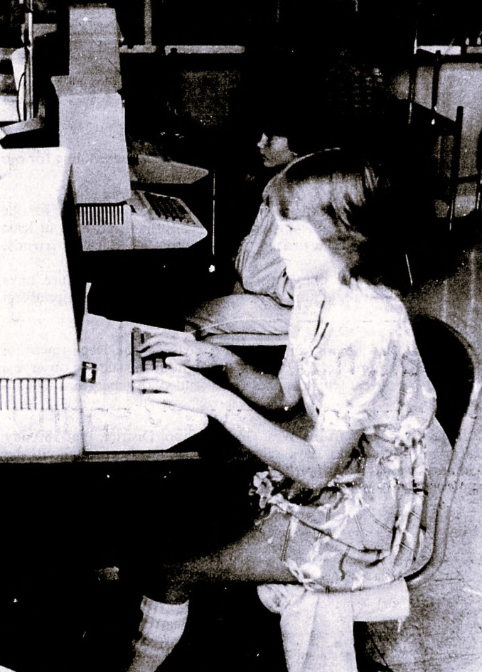 Two children work on early Apple computers.