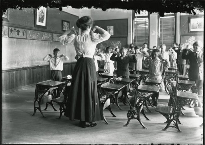 A teacher and her class of students exercise together.