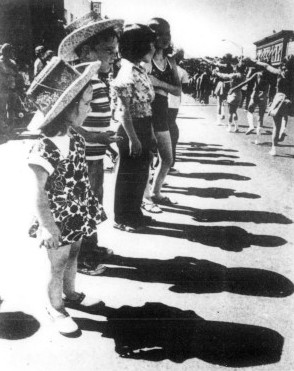 Several young children watch a parade.