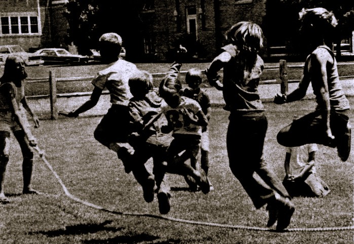 Five children jump rope together.