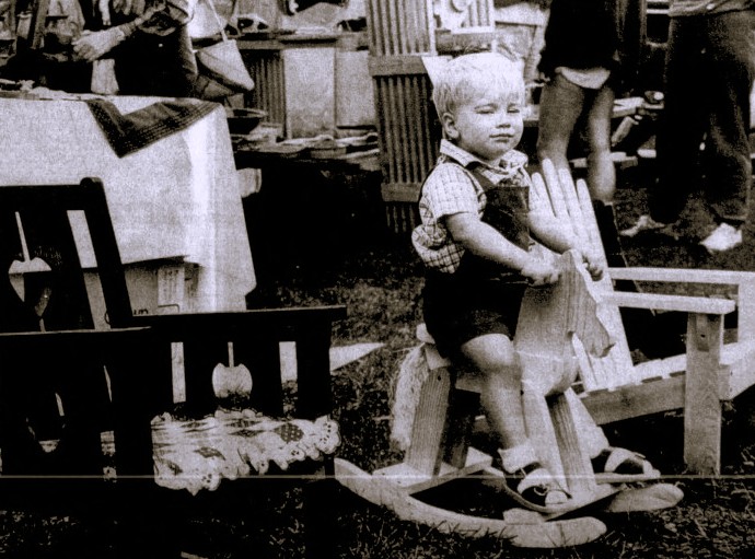 A toddler sits on a rocking horse