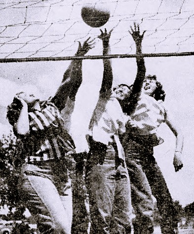 Three young women play volleyball
