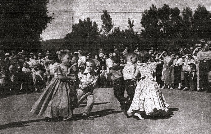 Several young children perform in a square dance exhibit.