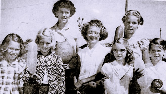 7 girls hold balloons.