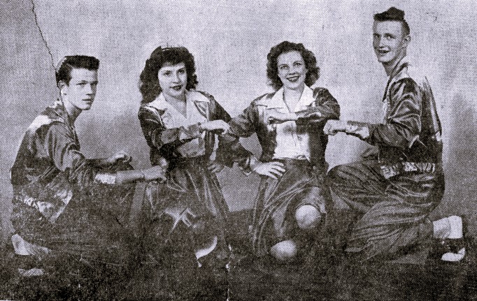 Two women and two men pose as members of a cheer squad.
