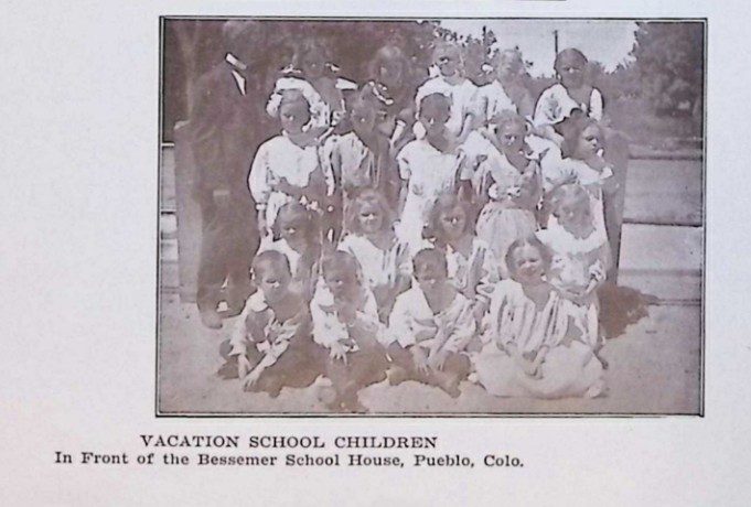 group of children and teacher, caption says "Vacation school children in front of the Bessemer School House, Pueblo, Colo."