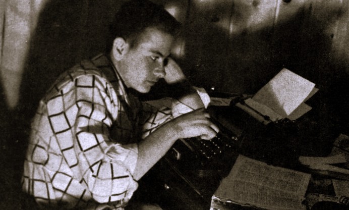 A student sits at a typewriter.