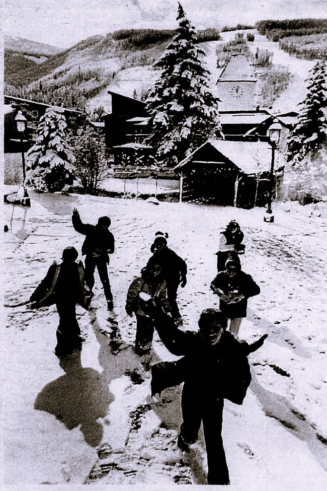 Seven children throw snowballs at the camera.