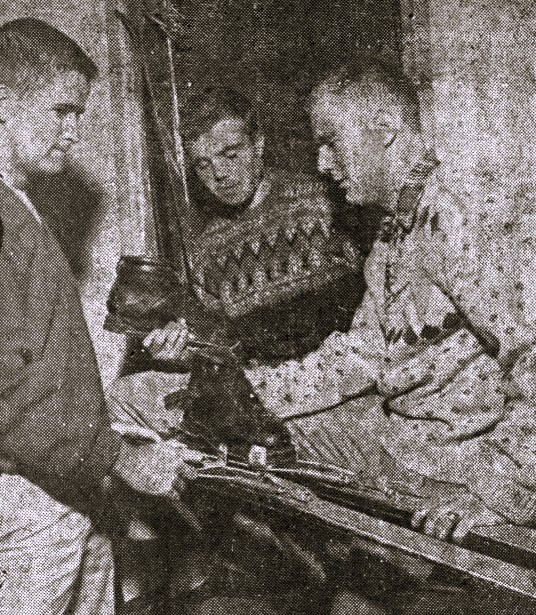 Three college men prepare skis and boots for ski season.