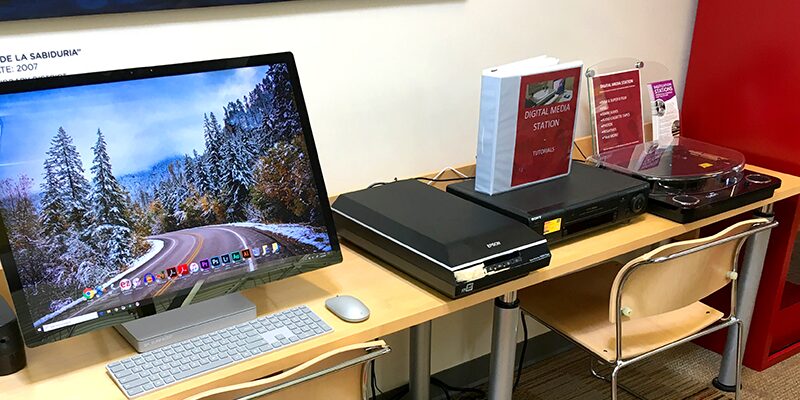 A digital media station featuring desktop computer, scanner, and audiovisual equipment.