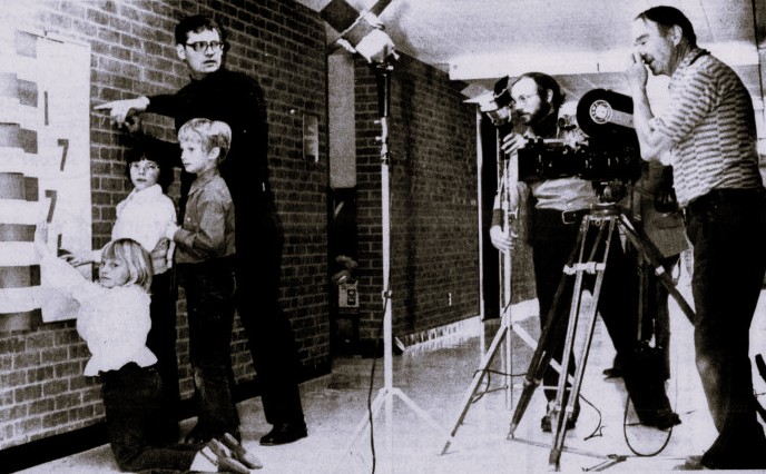 A production crew films children working on a Bicentennial display in their school.