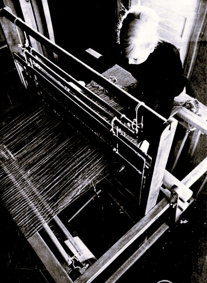 A woman works a loom.