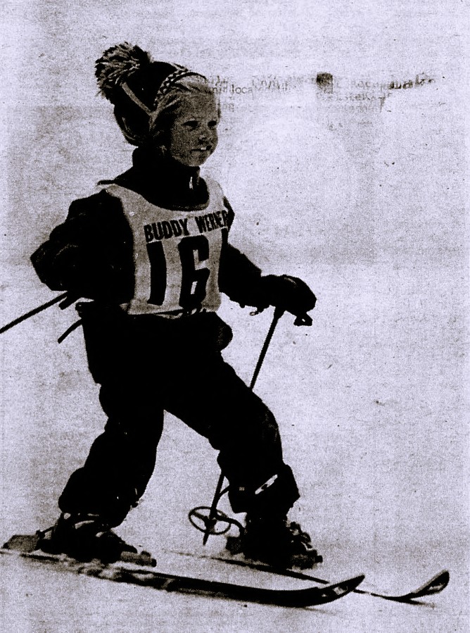 A young child participates in a ski race.