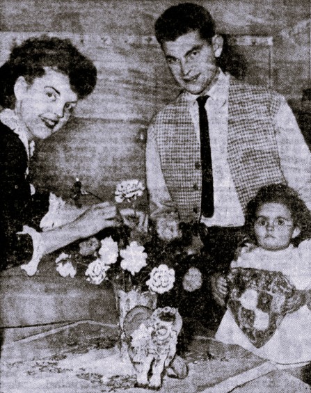 A family celebrates Valentine's Day with flowers and chocolates.