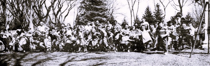 A large group of children begin an Easter egg hunt.