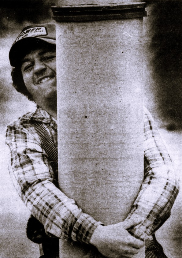 A man attempts to lift a large pillar.