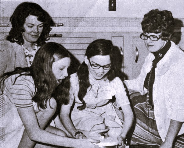 Two girls and two women make homemade ice cream.