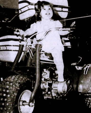 A young girl sits on an ATV.