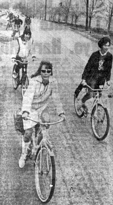 A group of teenagers ride bikes.