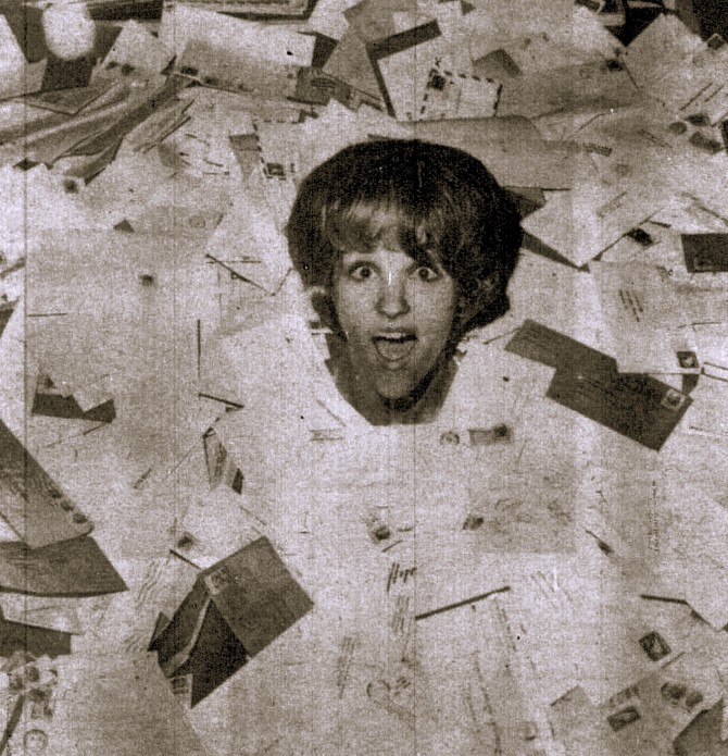 A woman is buried to her neck in mail.