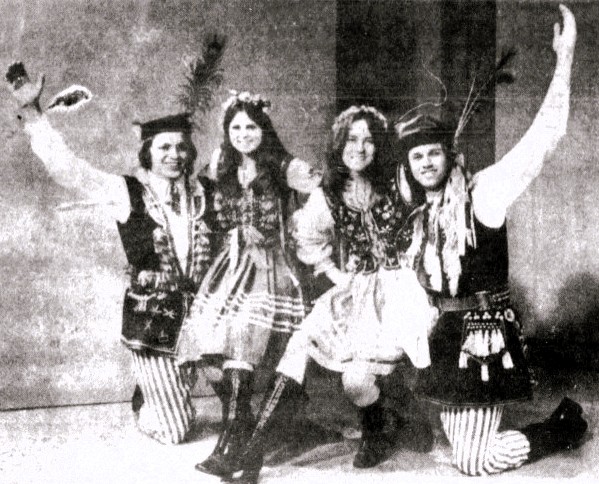 Four people pose in traditional Polish festival clothing.
