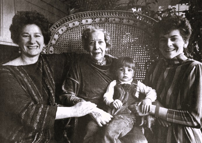 Four generations of women pose together.
