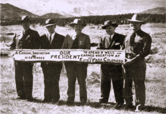 Five men hold a sign inviting the U.S. president to visit Estes Park.