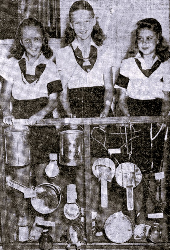 Three Girl Scouts display camping utensils they made from tin cans.