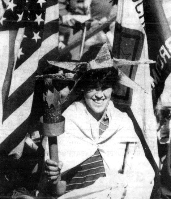 A woman is dressed as the Statue of Liberty.