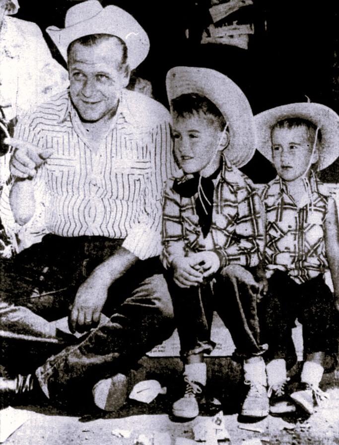 A father and his two sons watch a parade.
