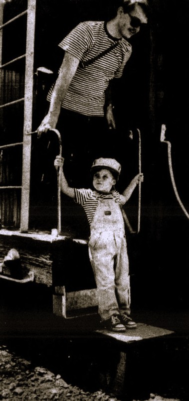 A father and son descend from a steam train.
