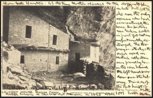 postcard with cursive writing and photo of cliff dwelling building