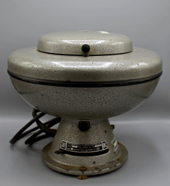 centrifuge: a metal device that looks like a bowl with a lid on a pedestal