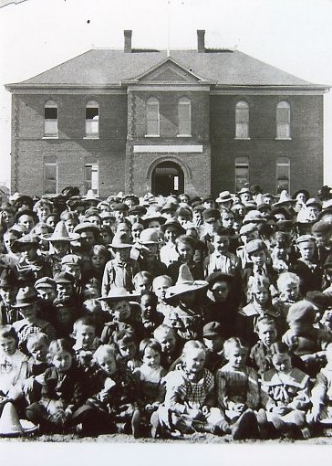 Dozens of students from Lawrence Grade School pose for a photo in front of their school.