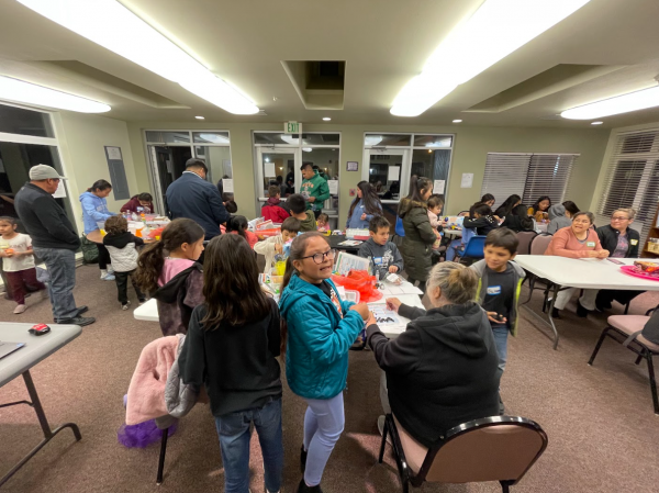 children and adults of different ages in a library room playing and meeting