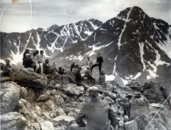 group of people sitting on rocks listening to preacher