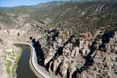 The I-70 highway follows the Colorado River through steep rocky walls of Glenwood Canyon.