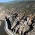 The I-70 highway follows the Colorado River through steep rocky walls of Glenwood Canyon.